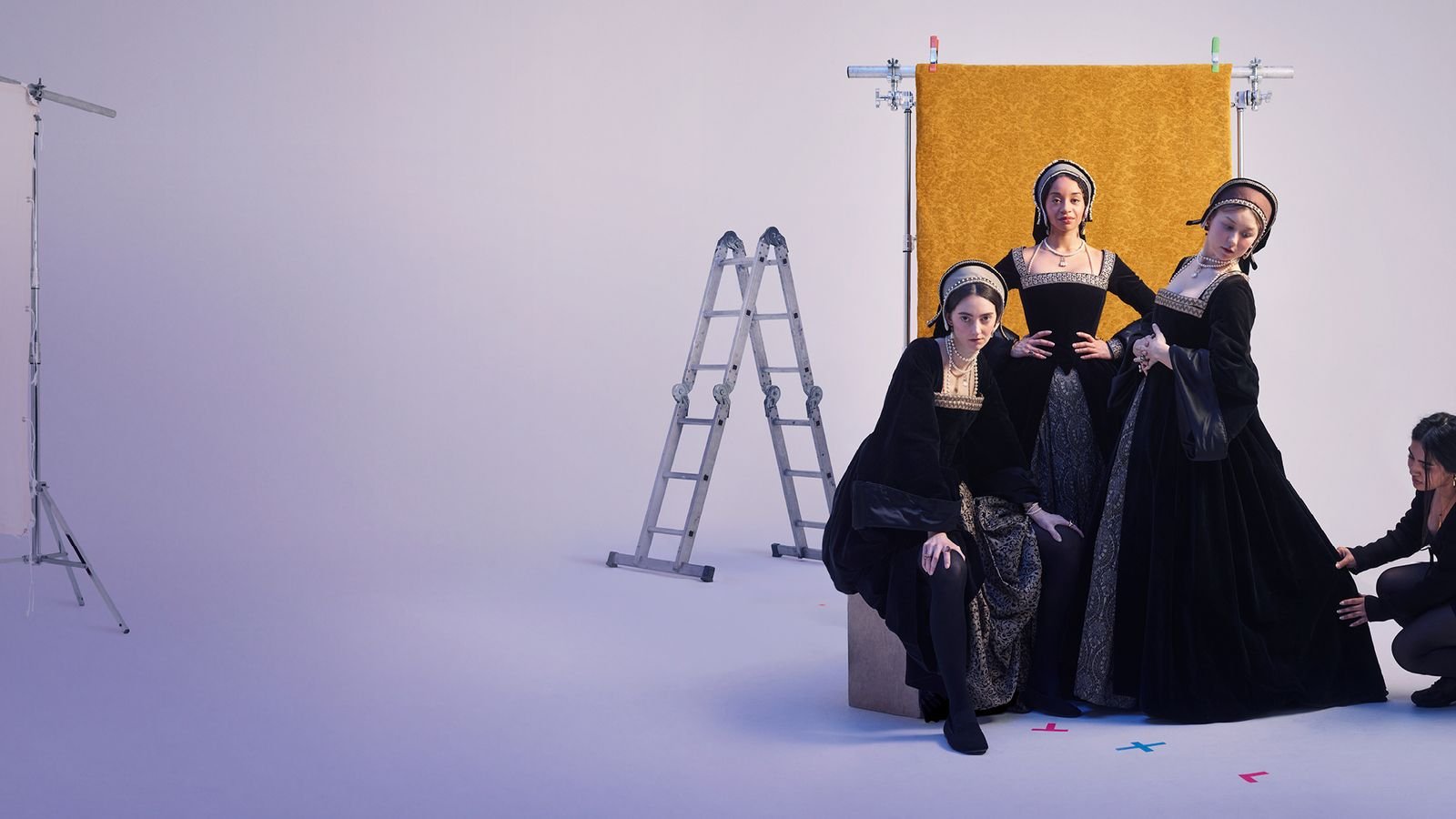 three women dressed in tudor style dresses against a white background for 1536 the play