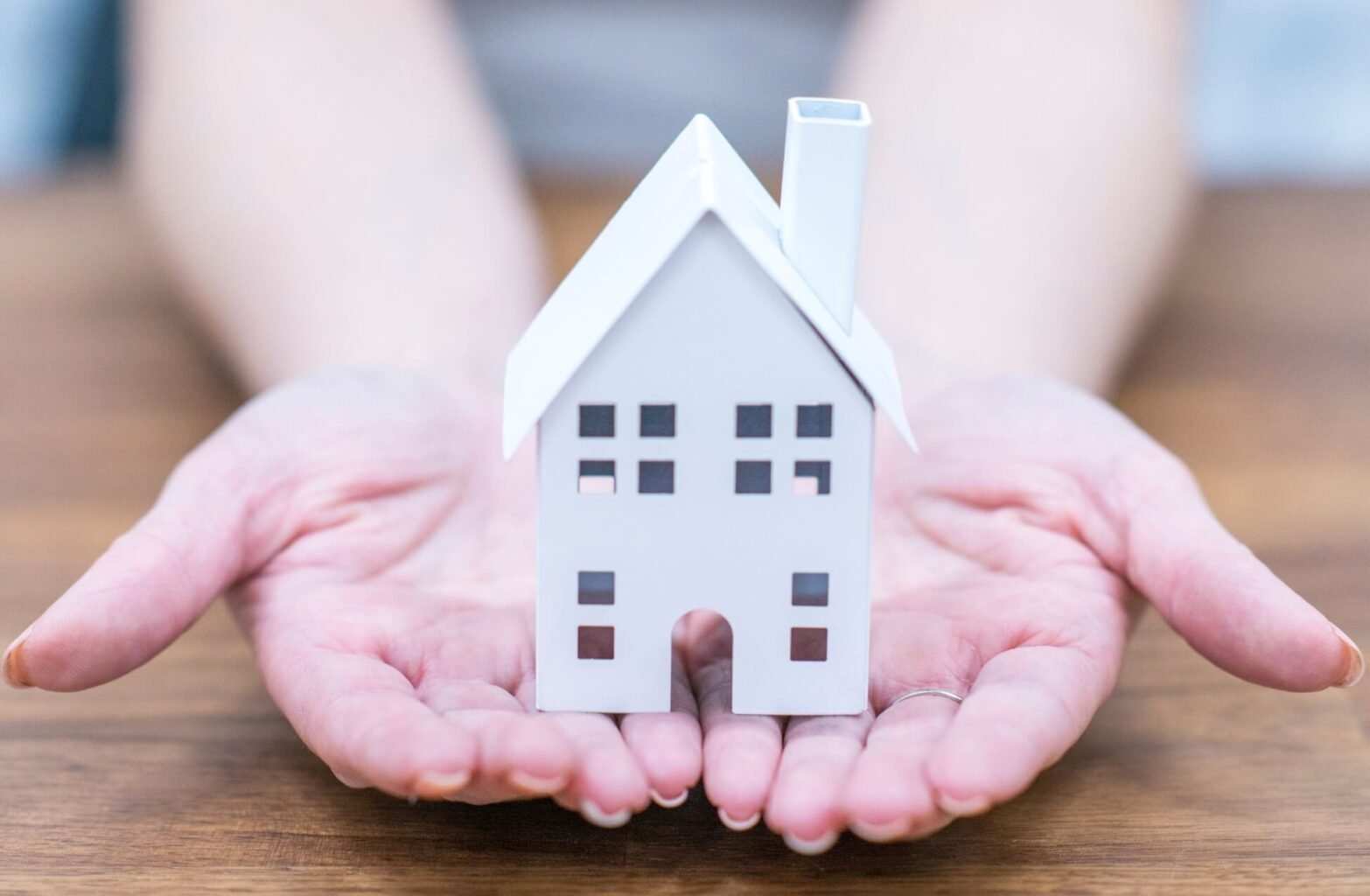 Woman Holding Toy House In Palm Of Hands - Gender Disparity First Time Buyers London