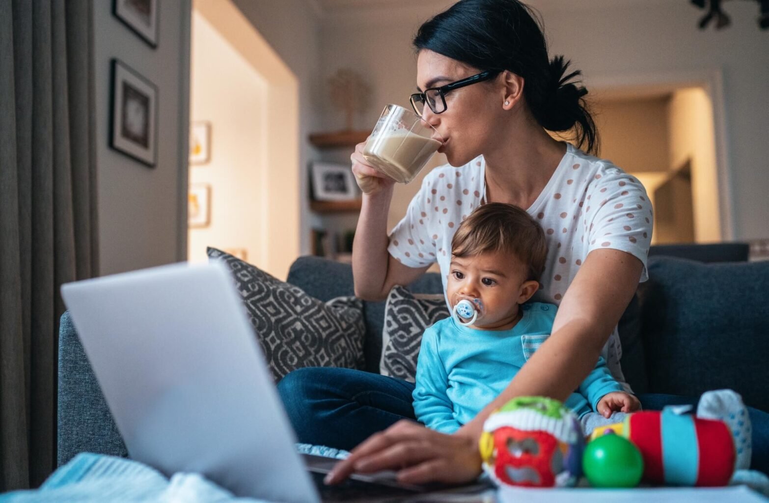 Working mum working from home drinking coffee balancing business and baby -female breadwinners mental load