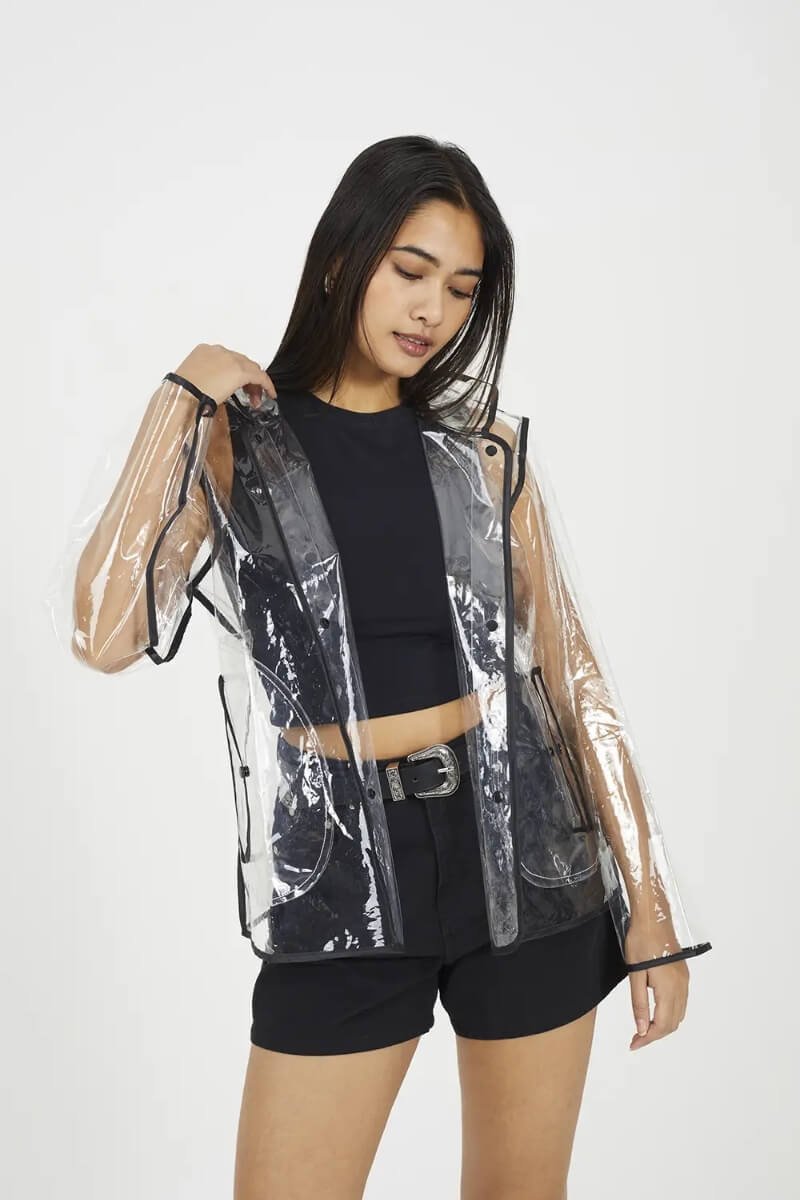 Model wearing Brave Soul clear hooded rain mac with contrasting black details over a black outfit