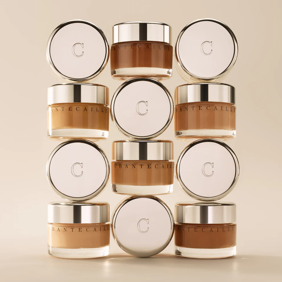 Twelve jars of Chantecaille Future Skin Foundation stacked in two columns with varying shades of foundation