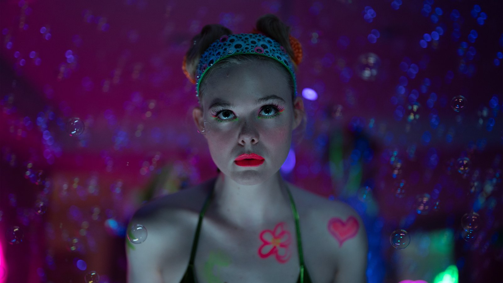 Elle Fanning as Margo, wearing neon makeup, and her hair is up in two pigtails in a scene from 'Margo's Got Money Troubles'.