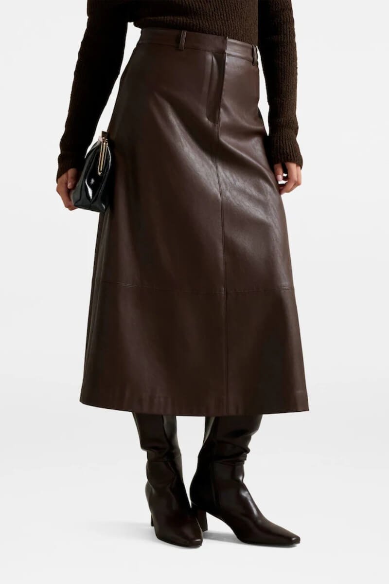 Forever New brown leather A-line midi skirt styled with knee-high boots and a black handbag