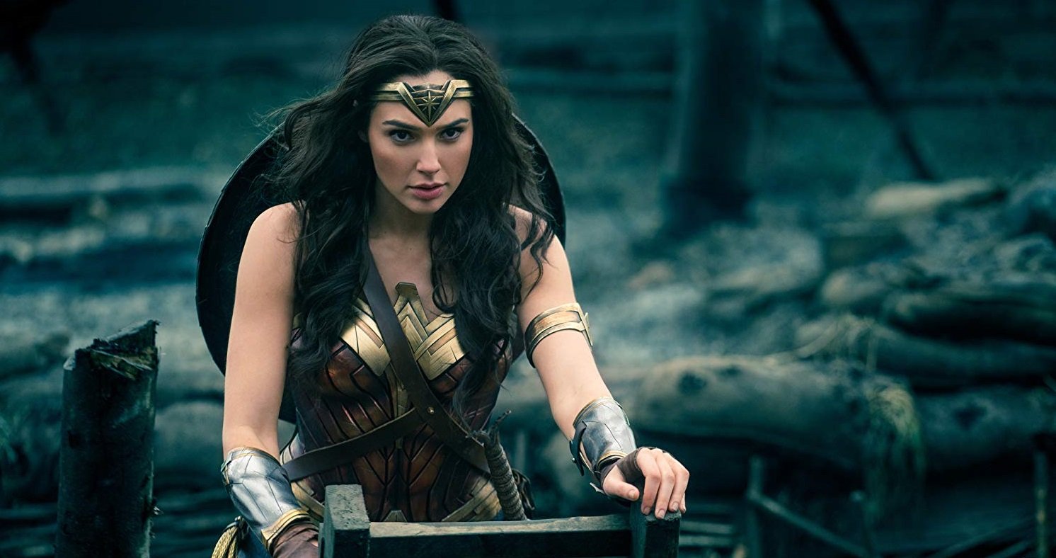 Gal Gadot as Diana, dressed in armor, with a crown made of steel on her head, and holding onto a staircase in a scene from 'Wonder Woman'.