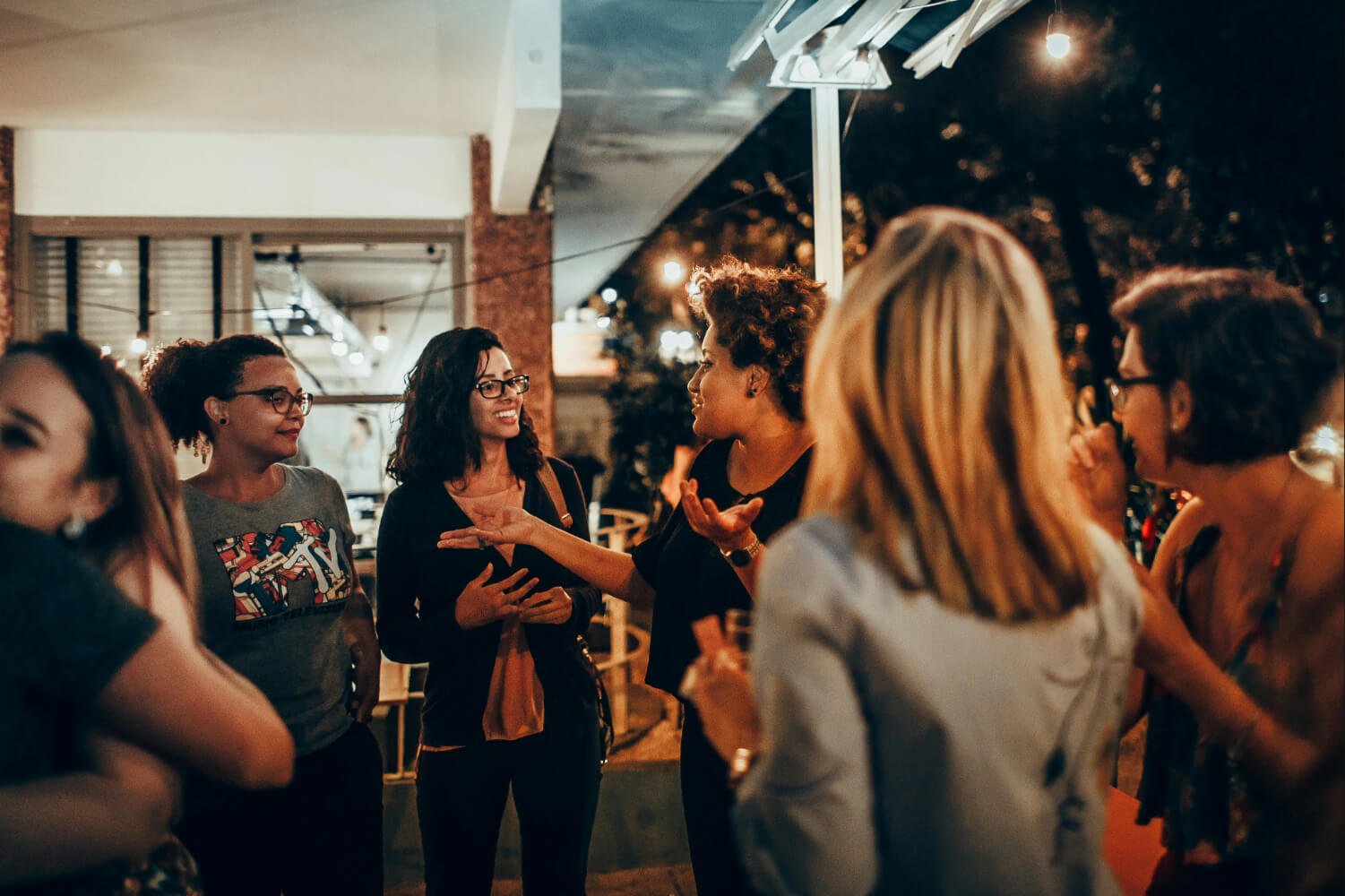 Group of women socialising and chatting together in a relaxed evening setting