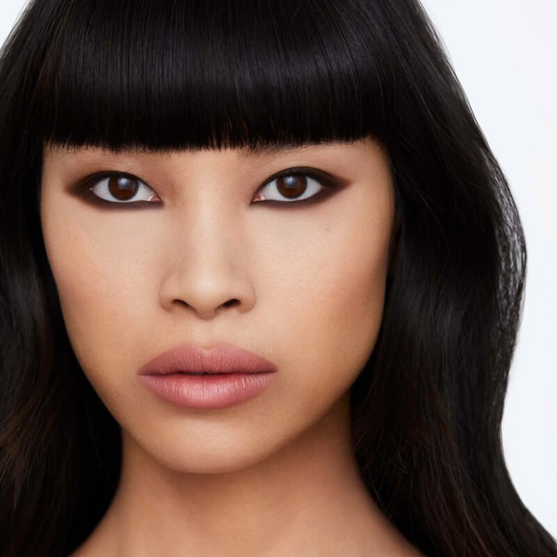 Model wearing Hourglass Cosmetics Voyeur Waterproof Gel Eyeliner, a bold eye makeup, featuring a nude lip colour