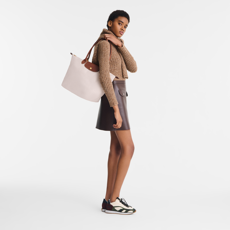 Model wearing Longchamp Le Pliage Original L tote bag in paper colour with brown leather handles.