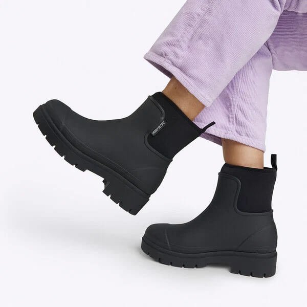 Merry People black ankle waterproof boots worn with purple corduroy pants
