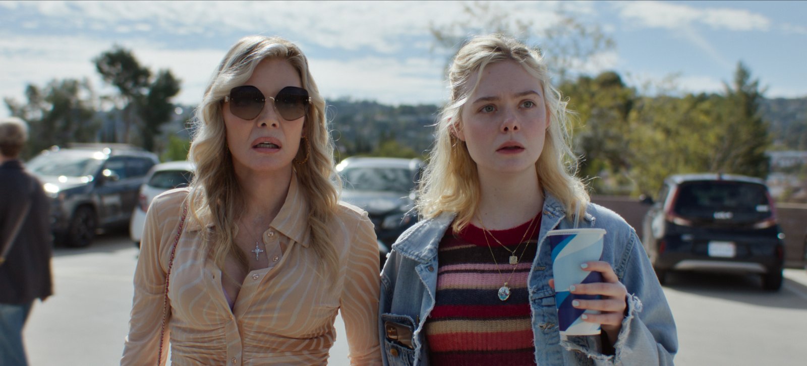 Michelle Pfeiffer as Shyanne and Elle Fanning as Margo are standing next to each other with stunned expressions in a scene from 'Margot's Got Money Troubles'.