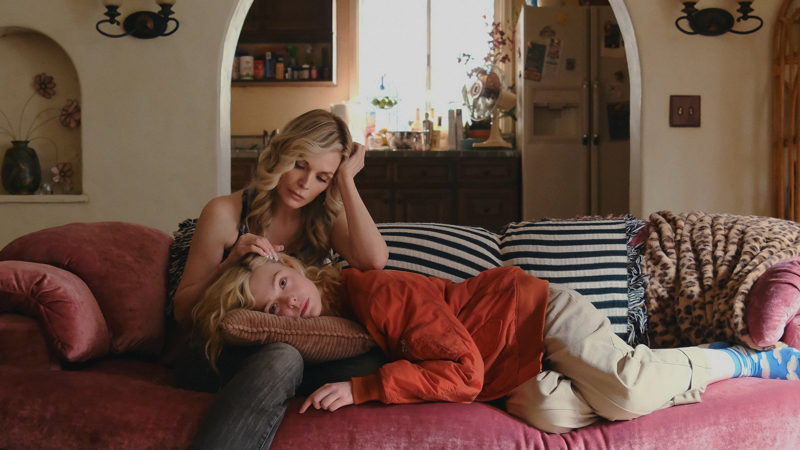 Michelle Pfeiffer caresses Elle Fanning's hair while the latter lies on her lap in a scene from 'Margo's Got Money Troubles'.
