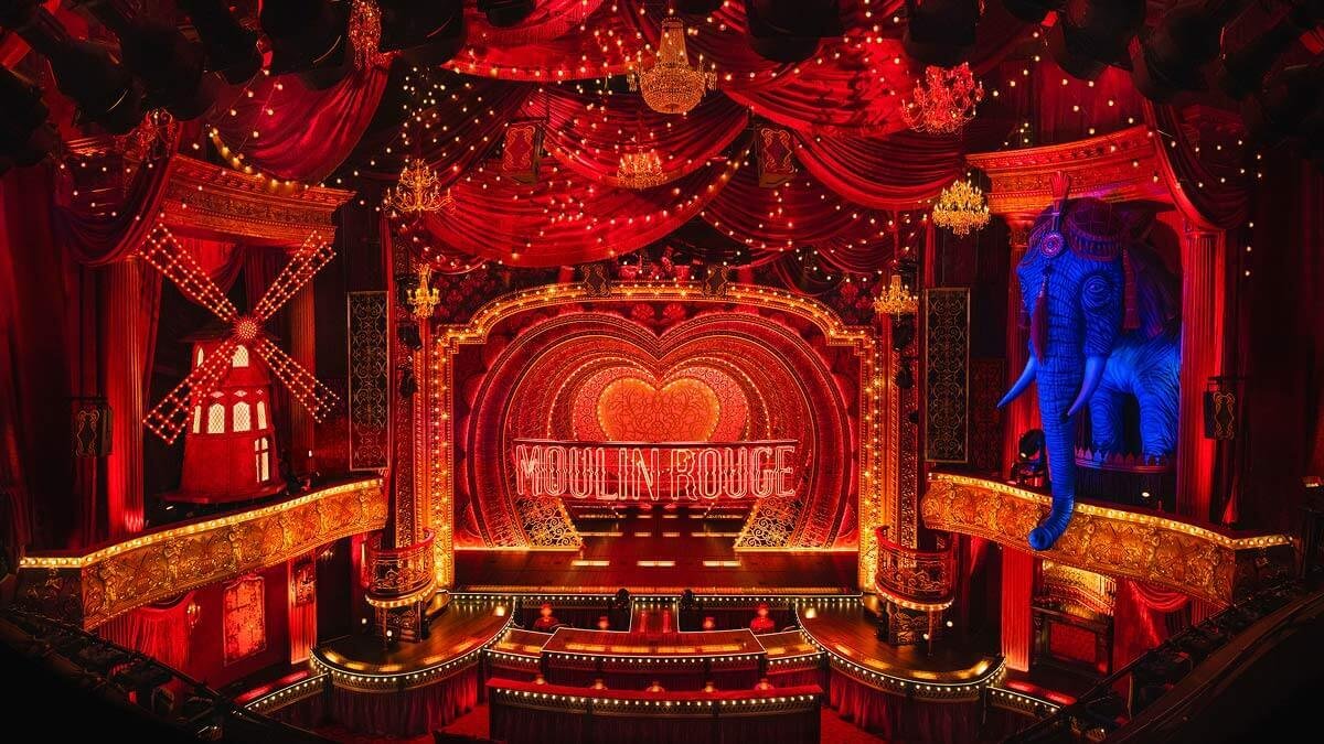 grand red theatre with red curtains and stage and seats with an elephant and heart with the words moulin rouge across the backdrop