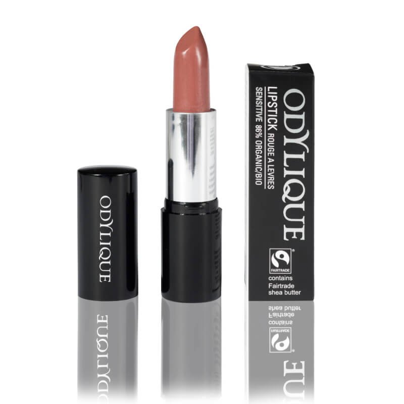 Odylique mineral lipstick in a beige tube, partially opened, next to its black cardboard packaging