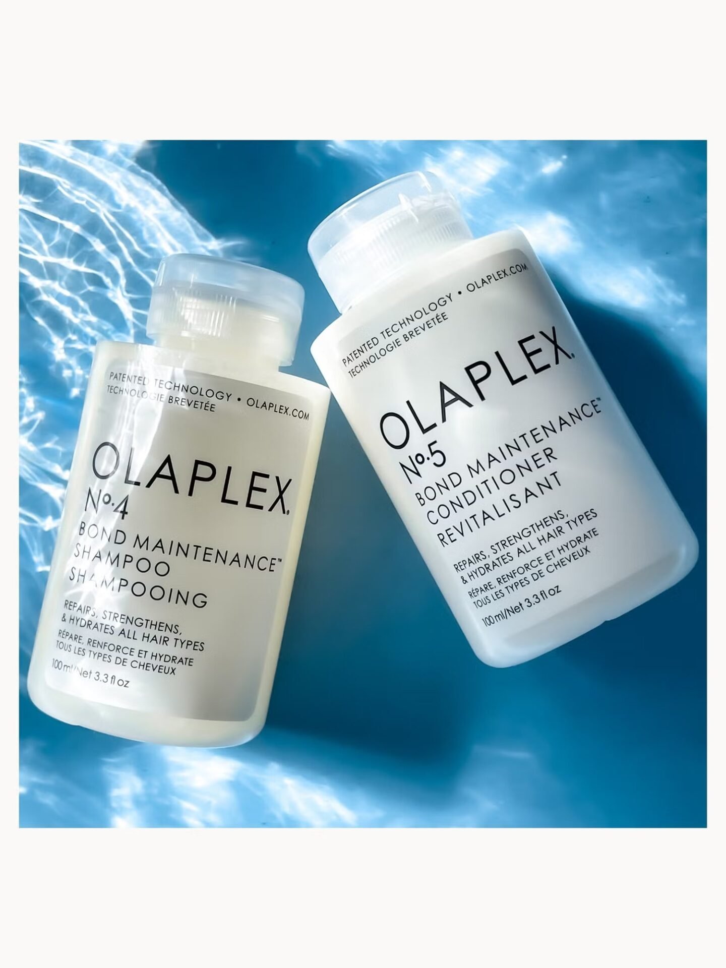 Two Olaplex Bond Maintenance bottles, No.4 Shampoo and No.5 Conditioner, sit on a blue, wavy background
