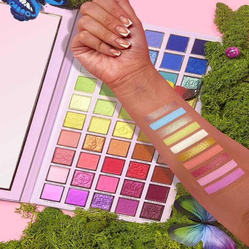 PL Louise AM PM palette next to vibrant eyeshadow shades on a model's arm