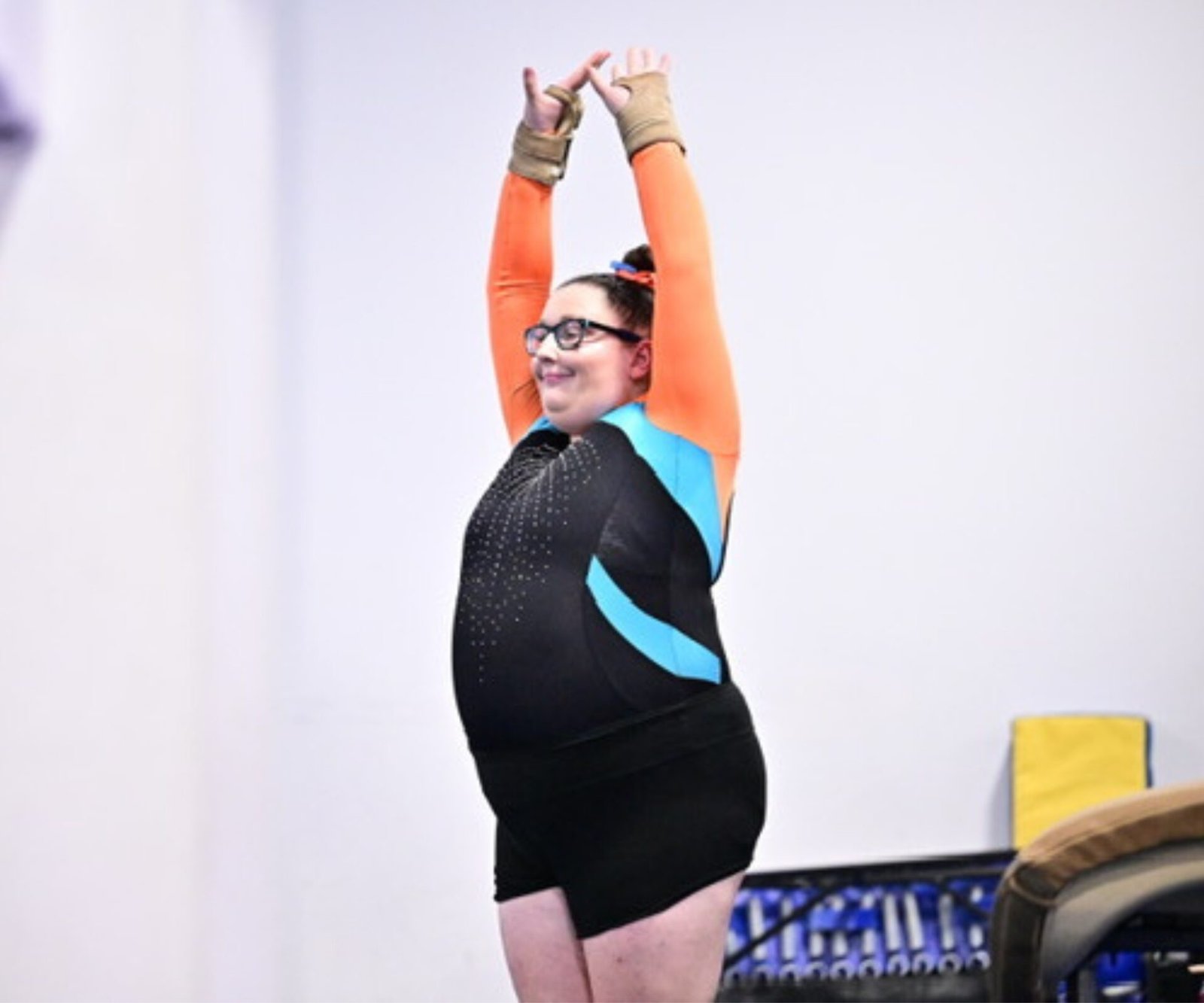 Plus-size gymnast Angela Salvatore competing at a gymnastics event, challenging stereotypes in the sport.