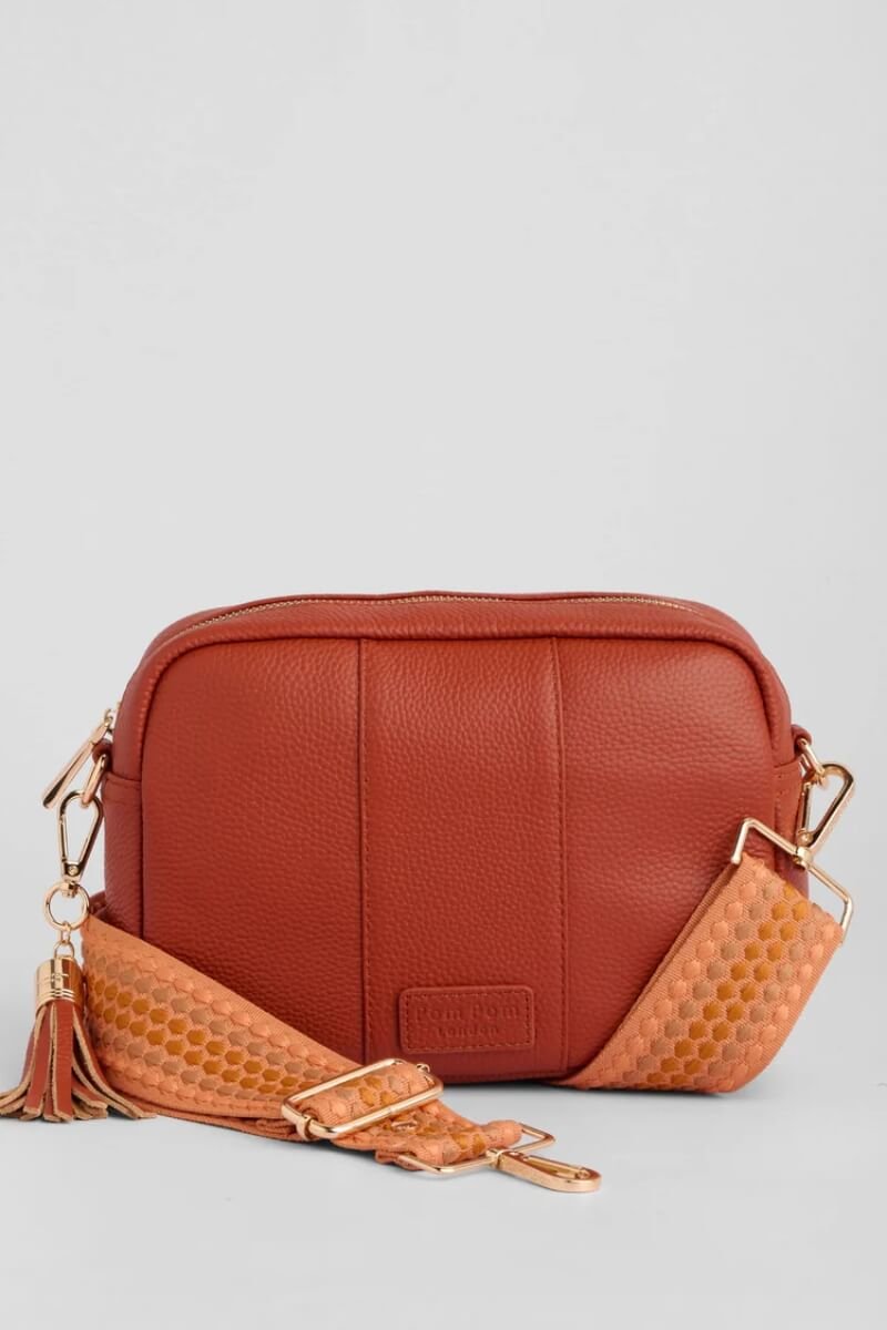 Pom Pom London burnt orange crossbody bag with a textured strap and tassel detail