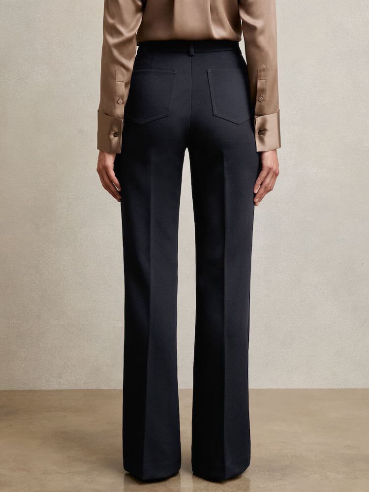 Back view of model wearing Reiss Priya Twill High Rise Flared Trousers in navy, women's high waist work trousers