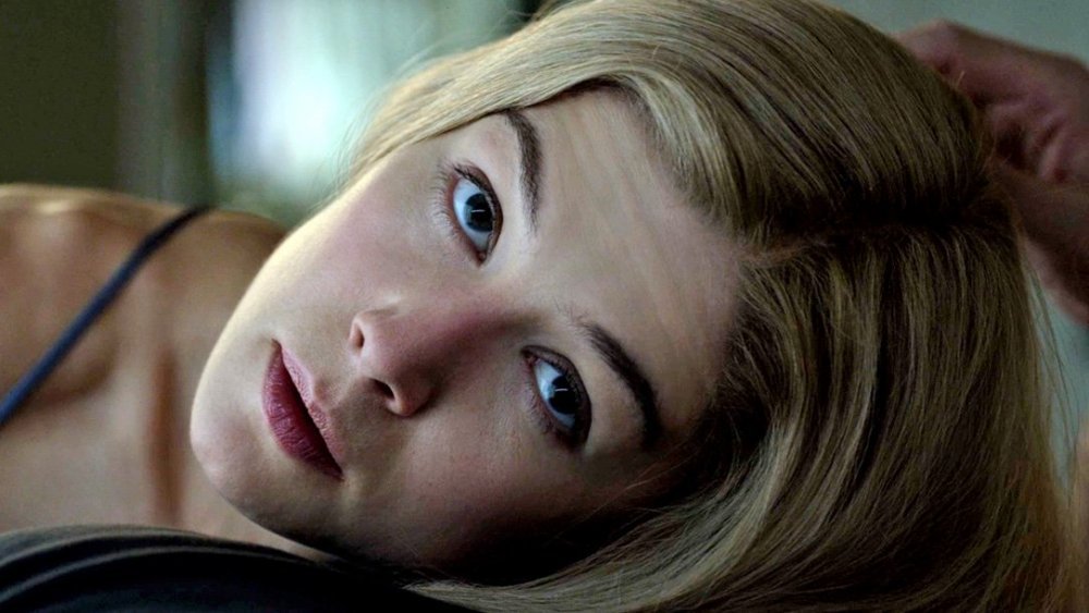 Close-up of Rosamund Pike as Amy Dunne lying down and looking directly at the camera in 'Gone Girl'.