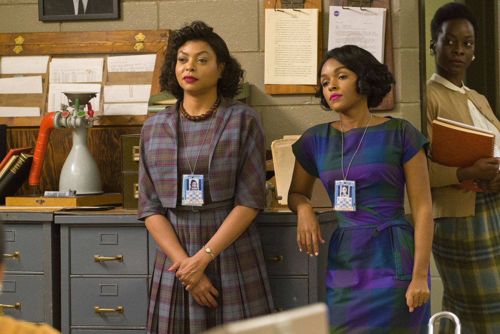 Taraji P. Henson as Katherine G. Johnson and Janelle Monáe as Mary Jackson, standing in a 1960s NASA office in a scene from 'Hidden Figures'.