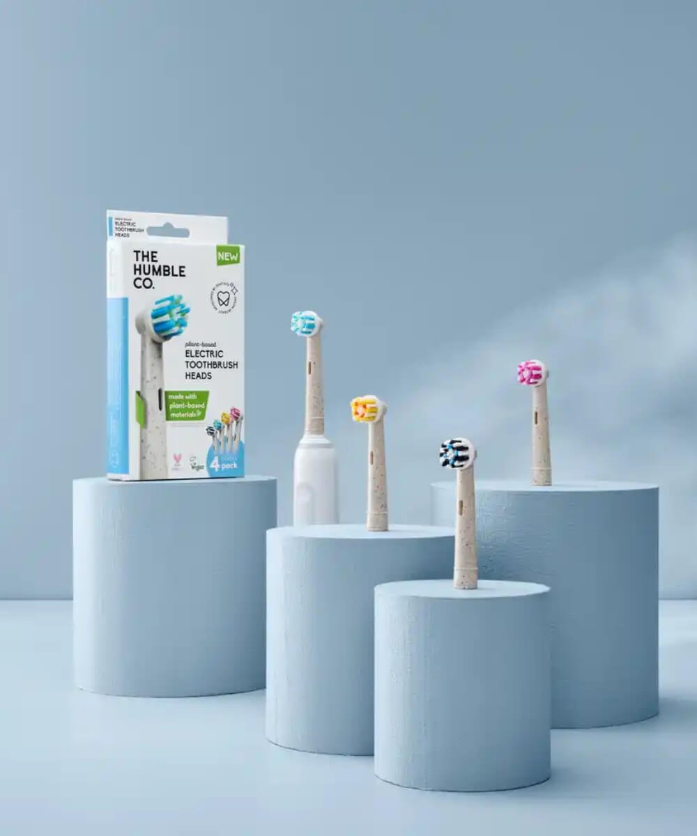 The Humble Co. plant-based electric toothbrush heads displayed on pedestals alongside a product box