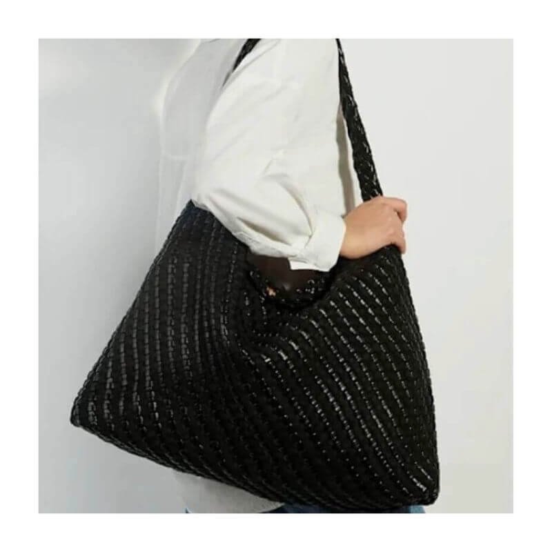 Model carrying Dune Deliberate XL black woven shoulder bag.
